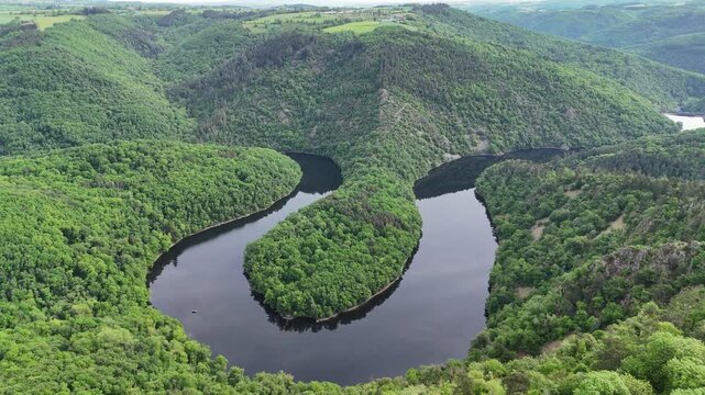 Vue a&eacute;rienne spectaculaire du m&eacute;andre de Queuille au c&oelig;ur d'une vall&eacute;e bois&eacute;e
