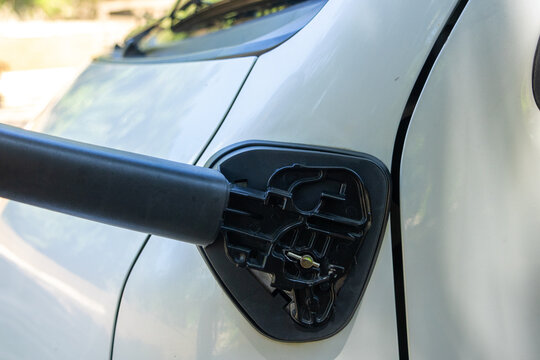 Close view of broken car side mirror showing frustrating damage to white vehicle after an auto accident, exposing black plastic mounting bracket needing urgent repair