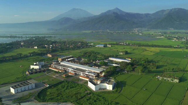 Aerial view of the historic Benteng Fort Willem I surrounded by lush green rice fields and distant mountains in Ambarawa, Central Java, Indonesia.