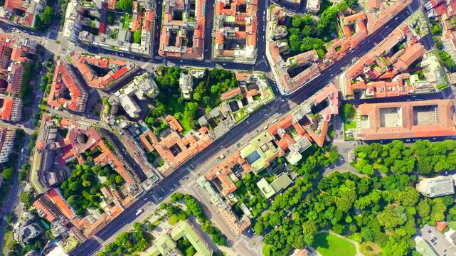 Milan, Italy. Drone footage over the historic city center, dense terracotta rooftops and classical architecture stretching across the urban grid under overcast skies. Drone footage, HEAD OVER SHOT
