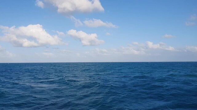 various shapes of clouds in the sky above the choppy sea