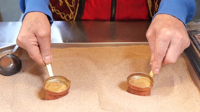 Making traditional Turkish coffee in sand with skill