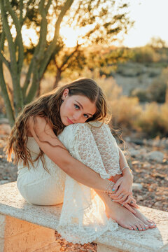 young girl sitting on a bench in the desert