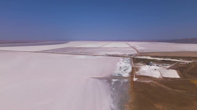 Aksaray, Turkey. Tuz Golu salt lake, vast geometric evaporation ponds and straight access roads cutting across white salt flats, aerial panoramic view under clear blue summer sky. Aerial View