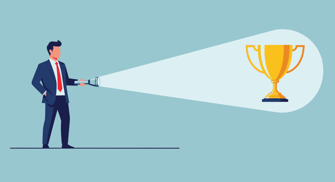 Business leader holding flashlight pointing at gold trophy symbolising vision target focus and achievement of company goals in competitive corporate environment.