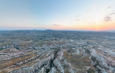 Goreme, Nevsehir, Turkey. Aerial view looking down onto Cappadocia's eroded valley slopes, revealing layered volcanic tuff formations and winding canyon floors below. Aerial view. © Video Render