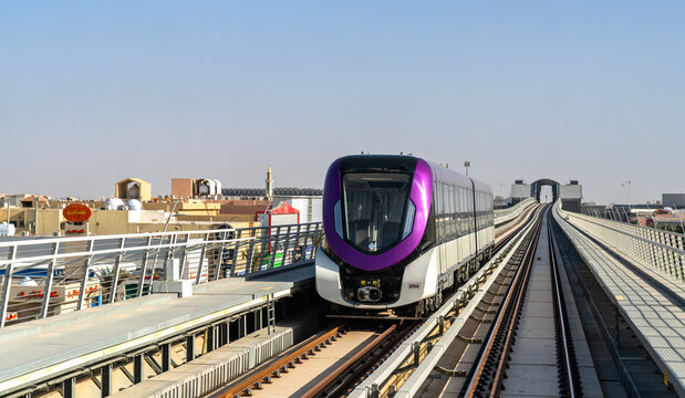 Riyadh, Saudi Arabia - February 21, 2026: A modern purple Riyadh Metro train travels along an elevated track through the Ishbiliyah district during the day