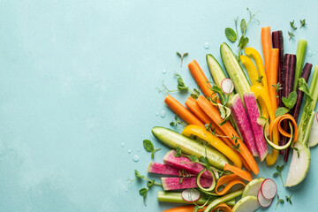 Obraz premium Fresh colorful vegetable sticks with carrots, cucumber, bell pepper, and watermelon radish