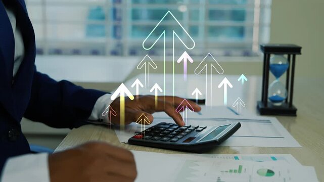 Businessman working on calculator with holographic arrow up growth, Professional accountant using a calculator with a hologram bar graph showing financial growth and data analysis