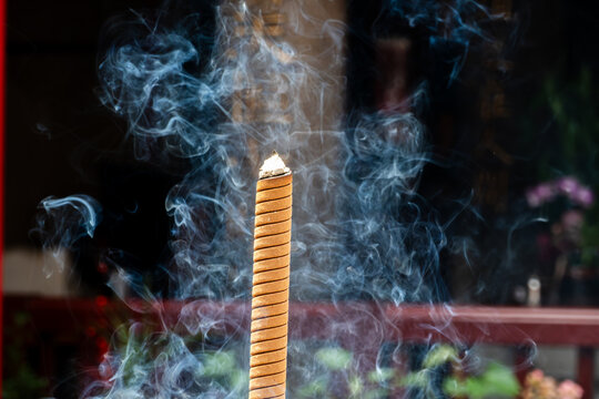 Beautiful swirling smoke from a burning joss stick, conceptual image for Zen, meditation, mindfulness, spiritual cleansing, and aroma relaxation.