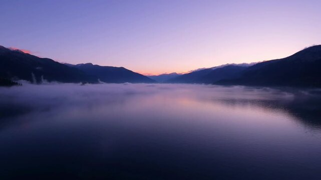 Foggy mountain lake at sunrise.