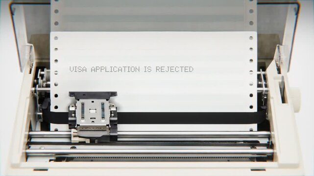 Old Dot Matrix Printer Printing VISA APPLICATION IS REJECTED Text on continuous white paper Close Up view.