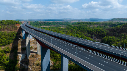 Fototapeta premium Samruddhi Expressway crossing forest landscape aerial view Maharashtra Samruddhi Mahamarg highway drone shot India