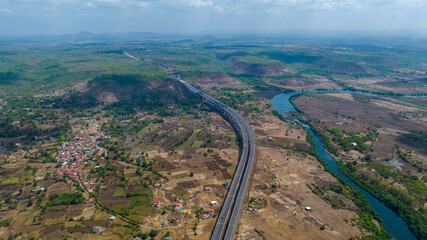 Fototapeta premium Samruddhi Mahamarg expressway aerial photography Maharashtra India Drone shot of Samruddhi Mahamarg highway through rural landscape