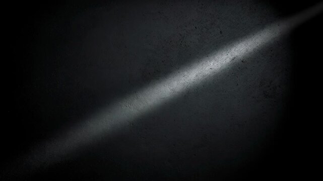 Dark textured surface with subtle light beam creating moody background and abstract shadow effect