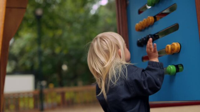 Young child intently manipulates vibrant beads on abacus panel