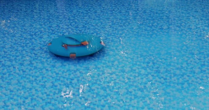 Floating robotic vacuum is works on blue surface in swimming pool during summer sunshine.