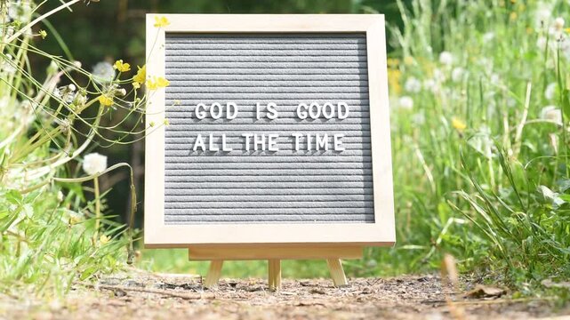  Letterboard with religious text God is good all the time in grass with flowers