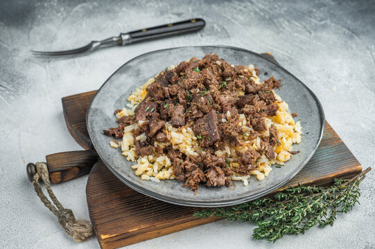 Turkish kavurma over pilaf showing browned fibers, maillard crust, collagen rich shredded meat and detailed macro texture on ceramic plate.