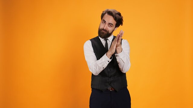 Friendly waiter giving confidence boost by applauding his hands in gratitude of recent accomplishment. Employee is cheering while he serves as butler in luxurious diner, presenting appreciation.