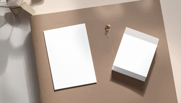A person places a stack of blank cards and a single card on a brown surface with a small object.