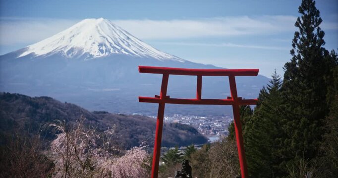 Beautiful wide shot of ancient torii gate on hill with view of Mt. Fuji