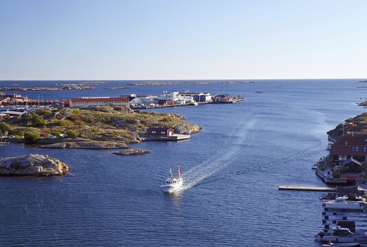 Small fishing village in the evening light, fishing boat sailing through archipelago, Baltic Sea, V&auml;stra G&ouml;talands l&auml;n, Sm&ouml;gen, Kungshamm, Sweden
