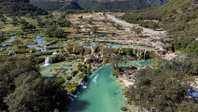 Aerial of turquoise waterfalls, Wadi Darbat, Salalah, Oman