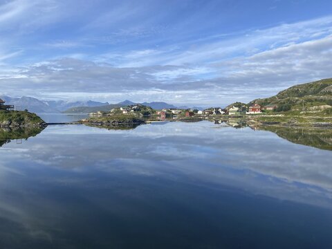 Crystal clear water and wooden houses reflected in the water, Sommar&oslash;y Island, summer, high mountains, tourism, Troms, Troms og Finnmark Province, Norway