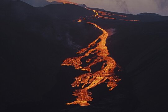 Glowing lava flows partly down mountainside, night shot, Fagradalsfjall, Reykjanes, Grindavik, Sudurnes, Iceland