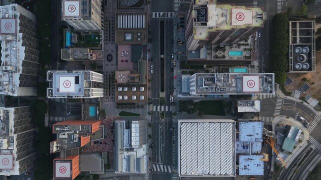 Top down city flying through downtown Los Angeles with skyscrapers and helipads on rooftops revealing modern urban architecture and busy car traffic on roads