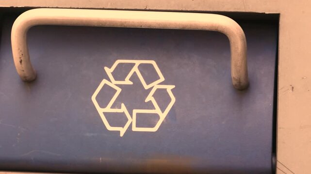 Waste bin with recycle icon in urban environment for sorting and recycling
