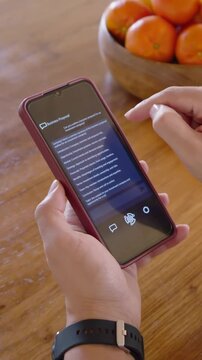 Vertical video: Tapping screen, hands scrolling Business Proposal to read at home, maroon phone