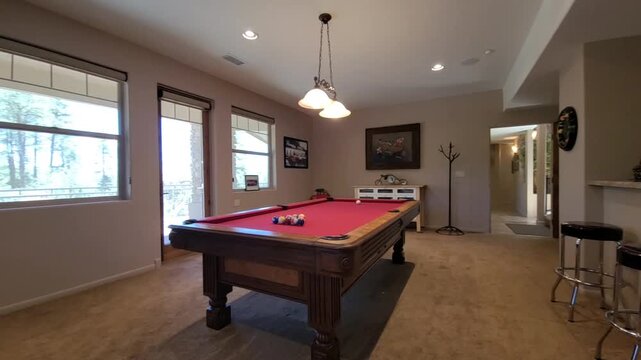 Cozy basement billiards room with red felt table