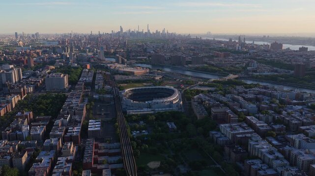 High angle establishing shot of South Bronx over Yankee Stadium with Manhattan skyline and Central Park in background during golden hour in New York City
