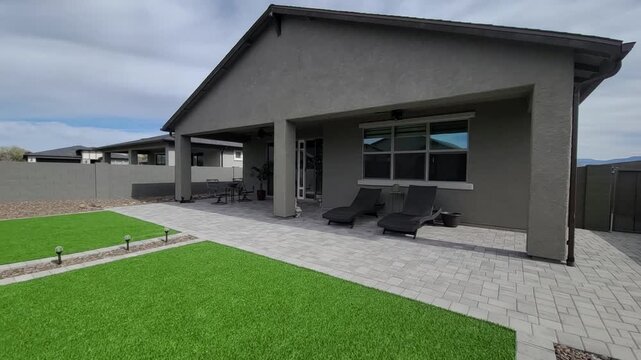 Contemporary backyard with covered patio and tidy landscaping