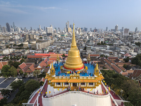 Bangkok, Thailand - 26 April 2026: Aerial view of Wat Saket Ratchawora Mahawihan, the Golden Mount, with its golden chedi and people on the terrace overlooking the urban skyline.