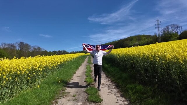 Proud man running with united kingdom flag in rapeseed field