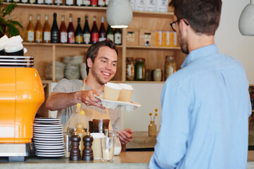 Barista, coffee and takeaway order with man in cafe for collection, hospitality or service. Giving, smile and to go with waiter serving customer at restaurant for pickup in small business startup © peopleimages.com