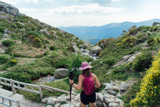 Woman hiking down a scenic mountain trail