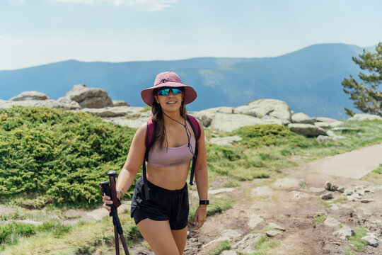 Young woman hiking on a sunny mountain trail