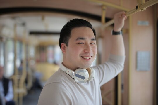 Happy young Asian man on public transport