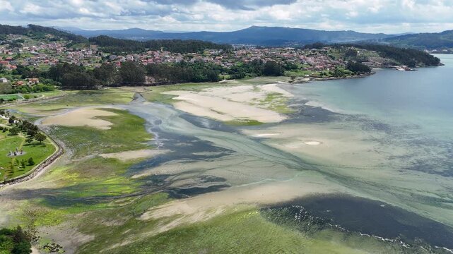 Aerial view of the Ria de Pontevedra estuary with sandy banks and green vegetation near the coastal town of Campelo, Pontevedra, Spain.