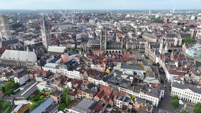 Aerial drone view of Ghent old town in Belgium, with the towers of St. Nicholas and St. Michael's Churches and Castle of the Counts next to river Lys. Architecture and landmarks of the medieval city.
