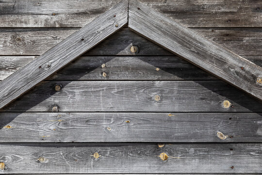 Shape of a house roof made of wooden beams on a wooden background