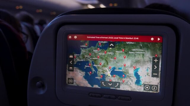 In-flight entertainment screen displays flight map with estimated arrival time and current altitude over Europe and Mediterranean region