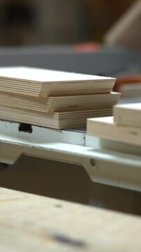 Expert Cabinetmaker Carefully Stacking And Organizing Plywood Pieces Under Bright Factory Lights. Media