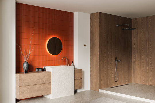 Modern bathroom interior with warm wood panel shower, orange tile wall, illuminated round mirror, minimalist sink and cabinetry in refined contemporary design. 3D Rendering