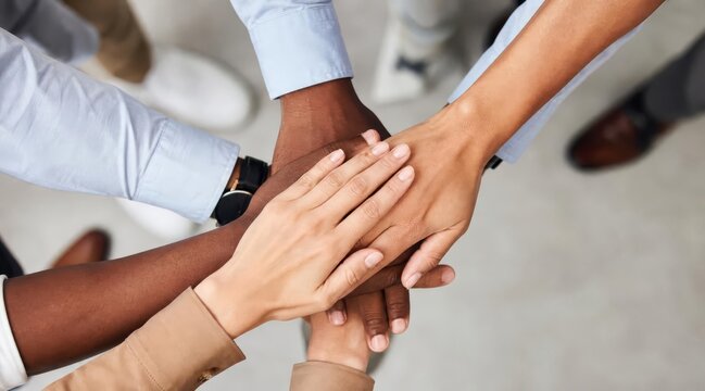 Diverse group stacking hands for unity