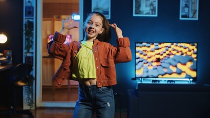 Kid influencer having fun dancing in home studio, recording video for generation z internet users. Girl doing skillful dance moves, following online choreographic trends from favorite celebrities